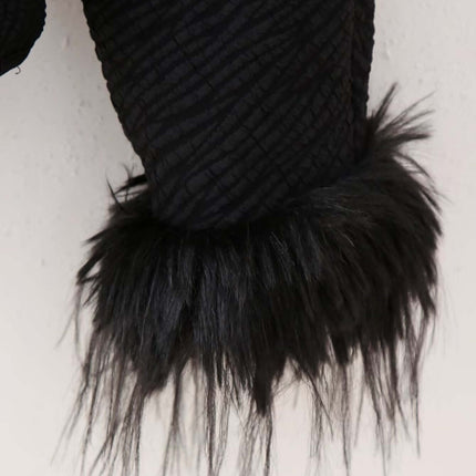 Close-up of Fur Cuff Single Breasted Jacket showcasing luxurious black fur-trimmed cuffs against a textured fabric background.