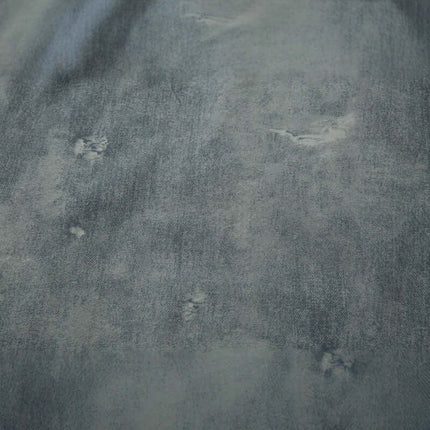 Close-up of the fabric texture of the Letter Applique Washed Hoodie – Loose Fit, showcasing distressed detailing and a faded look.