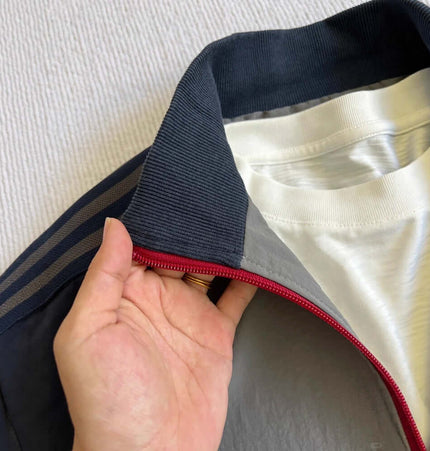 Three-Stripe Sports Jacket - Loose Fit with stand collar and zipper detail, showing interior lining and fabric.