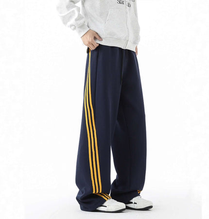 Heavyweight Three-Stripe Pants - Loose Fit featuring a relaxed fit and bold three-stripe design in navy and yellow.