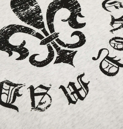 Close-up of a black vintage floral emblem design printed on light fabric.