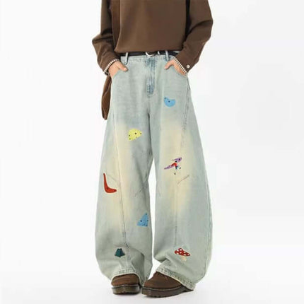 Embroidered Patchwork Denim Pants featuring playful designs and a loose fit for trendy urban streetwear style.