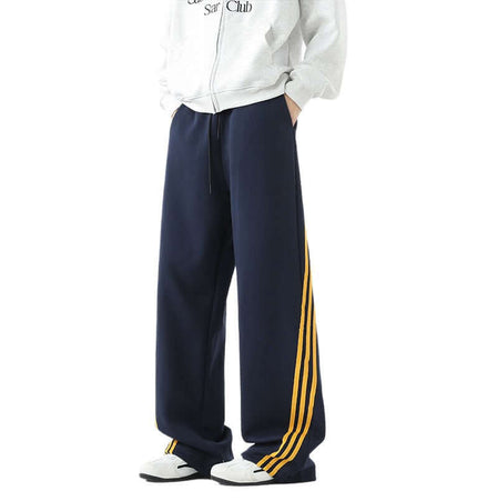 Heavyweight Three-Stripe Pants - Loose Fit in navy with yellow stripes for sporty comfort and style.