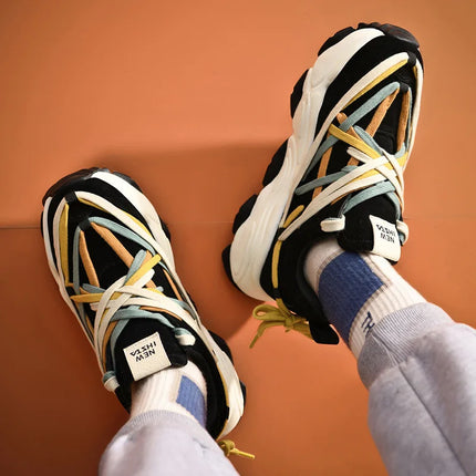 Fashionable organic cotton luxury sneakers with multicolored laces, showcasing a relaxed and breathable design on an orange background.