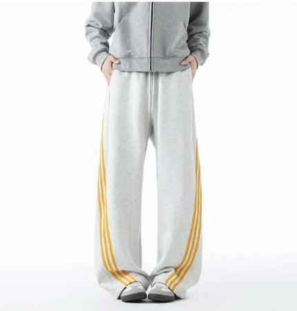 Heavyweight Three-Stripe Pants - Loose Fit featuring a relaxed fit and straight-leg silhouette with yellow stripes.