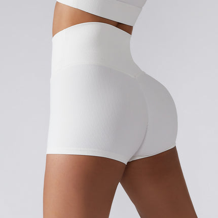 Woman wearing high waist lift yoga shorts in white, ribbed texture, ideal for fitness and comfort, made from organic cotton blend fabric for a relaxed fit