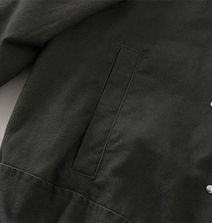 Close-up of the fabric and pocket detail of the Stand Collar Casual Jacket – Loose Fit in dark gray.