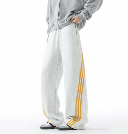 Heavyweight Three-Stripe Pants - Loose Fit in grey with yellow stripes for a sporty and relaxed style.