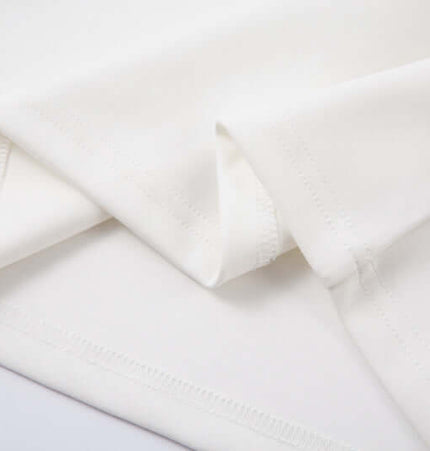 Close-up of soft, white cotton fabric showcasing the texture used in the Retro Embroidered Patchwork Polo Hoodie.