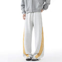 Heavyweight Three-Stripe Pants - Loose Fit in gray with orange stripes and elastic waistband for sporty comfort.