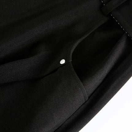 Close-up of the fabric detail on Wide Leg Pleated Plaid Trousers showcasing the button and soft texture.