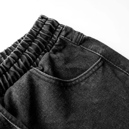 Close-up of the waistband and pocket of Distressed Pleated Reverse Denim Pants showcasing washed denim texture.