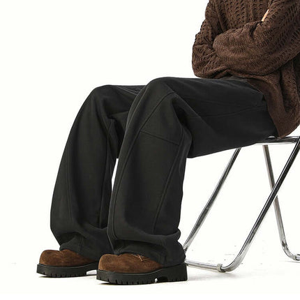 Person wearing Heavyweight Wide-Leg Pants - Loose Fit, seated on a chair with a stylish outfit.