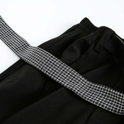 Close-up of the Wide Leg Pleated Plaid Trousers featuring a plaid ribbon detail and elastic waistband.