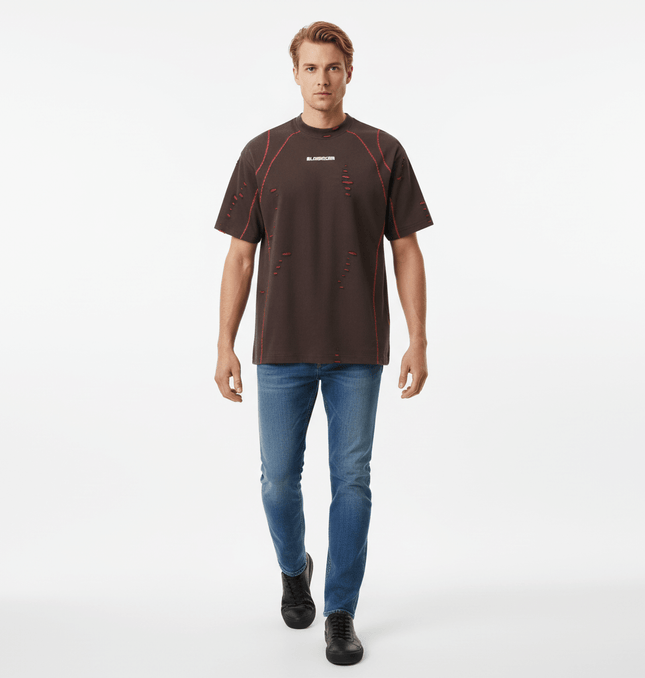 Distressed Short Sleeve TShirt – Loose Fit worn by a model in a casual setting with ripped details and a stylish look.