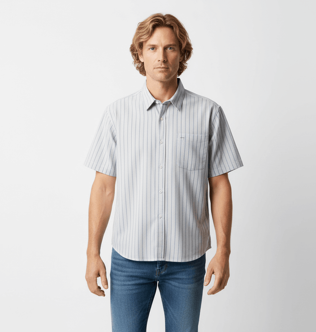 Patch Striped Short Sleeve Shirt - Loose Fit worn by a man, featuring a light blue and white striped pattern.