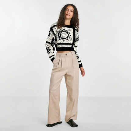 Camellia Jacquard Beaded Knit Sweater styled with wide-leg beige pants and black shoes in a bright studio setting.