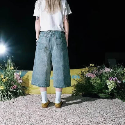 Person wearing Cartoon Dog Embroidered Denim Shorts featuring a trendy washed blue finish and relaxed fit.