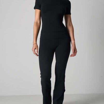 Casual Fit Cotton Jersey Yoga Set worn by a woman, showcasing a short sleeve crop top and high-waist flare pants.