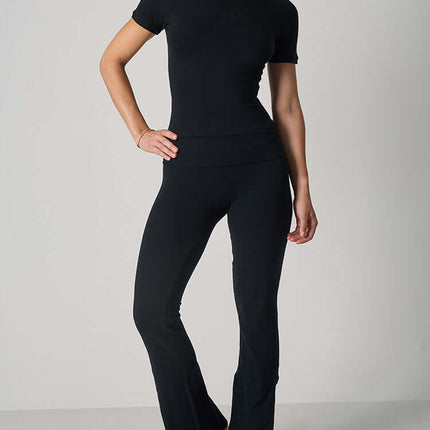 Casual Fit Cotton Jersey Yoga Set worn by a woman, featuring a short sleeve crop top and high-waist long flare pants.