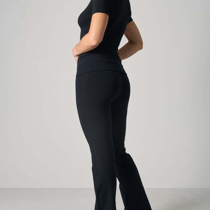 Casual Fit Cotton Jersey Yoga Set - Woman in stylish black crop top and high-waist flare pants, ideal for yoga and casual wear.