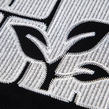 Close-up of cross embroidered detail on the Cross Embroidered Hoodie – Loose Fit, showcasing intricate stitching and design.