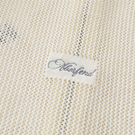 Close-up of the label on the Hooded Embroidered Knit Cardigan, showing delicate embroidery details.