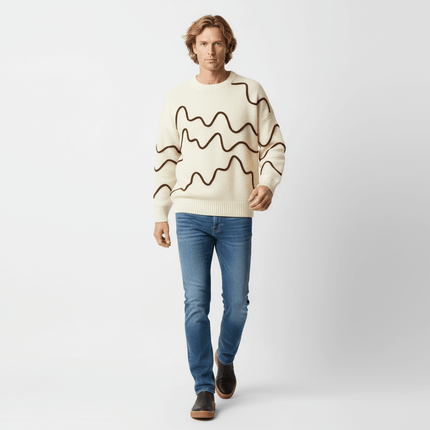 A model wearing the Color Block Line Knit Sweater – Loose Fit, featuring stylish wave designs and casual jeans.