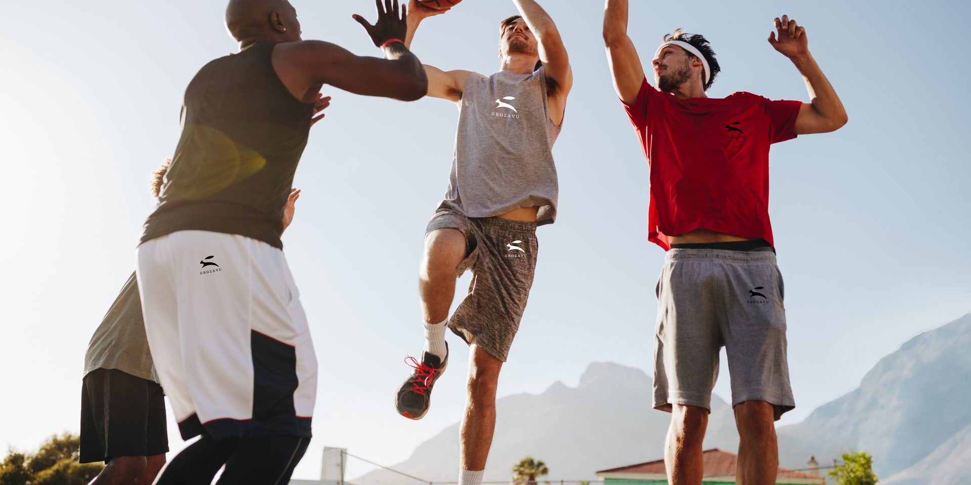 Grozavu men playing outdoor basketball in grey tank, red tee and performance shorts with rabbit logo, athletic fit
