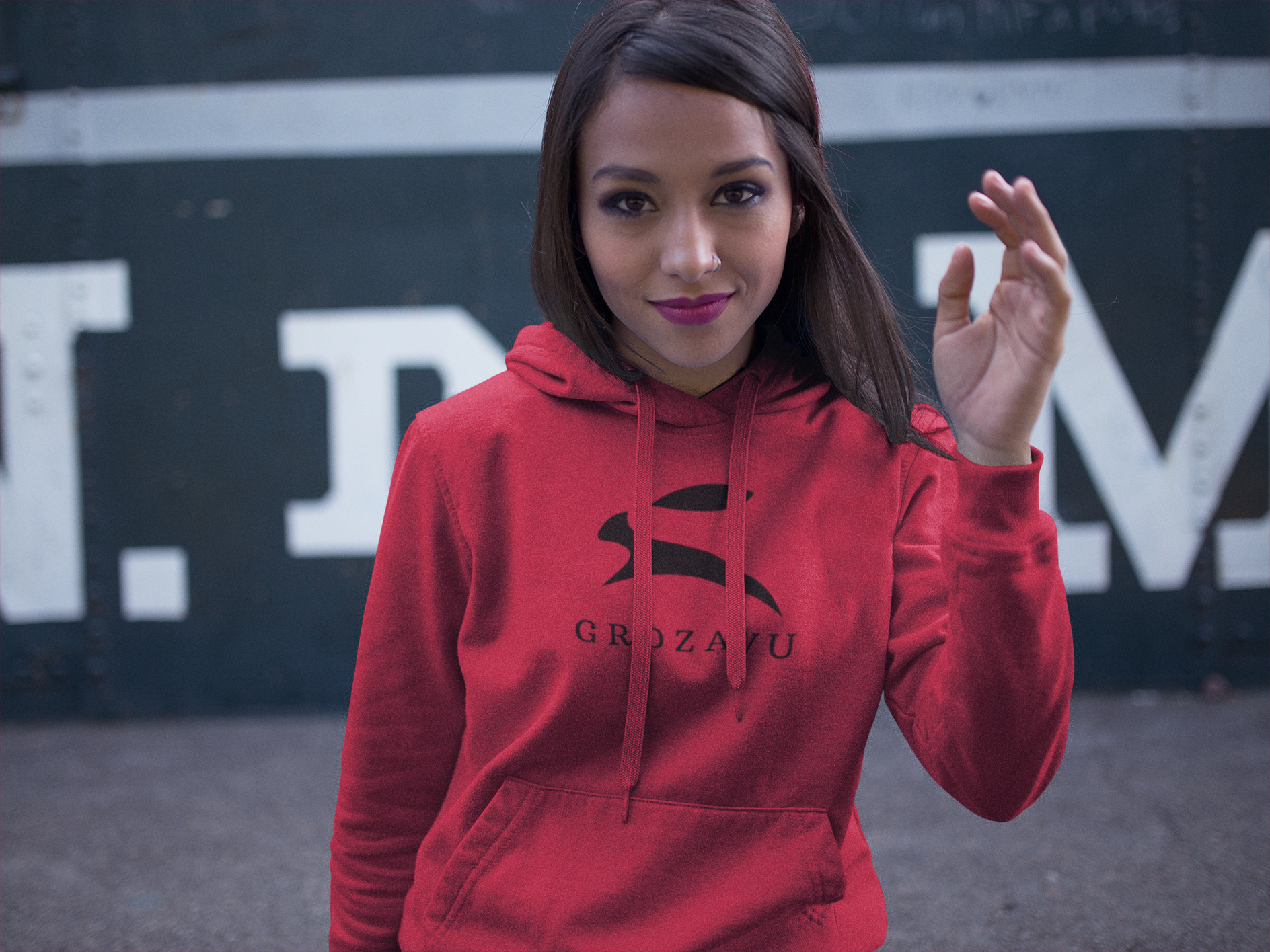 Woman wearing red Grozavu logo hoodie with black rabbit emblem, urban streetwear front view