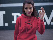 Woman wearing red Grozavu logo hoodie with black rabbit emblem, urban streetwear front view