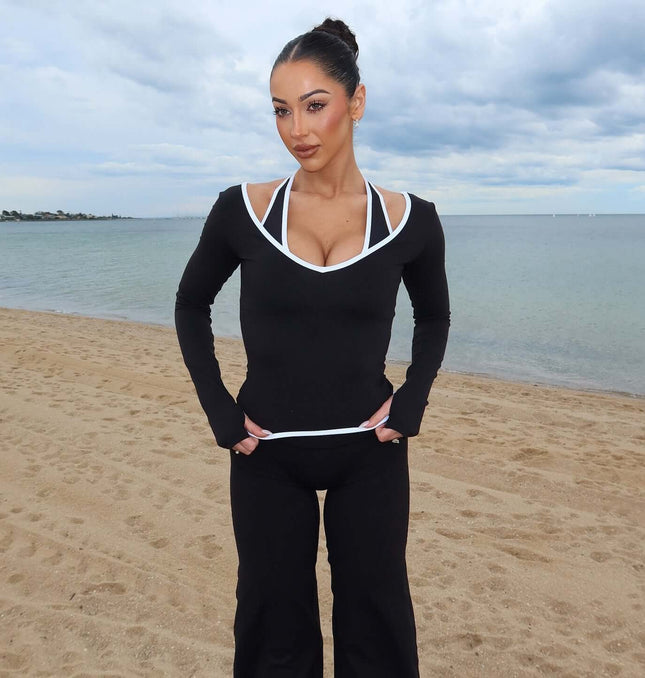 Model wearing Long Sleeve Halter Neck Contrast Top by the beach, showcasing its sleek design and modern style.