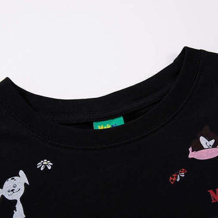Close-up view of the MoKesch black t-shirt featuring playful cartoon animal graphics.