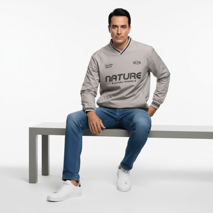 Man sitting on a bench wearing a gray Nature jacket, showcasing outdoor style and comfort.