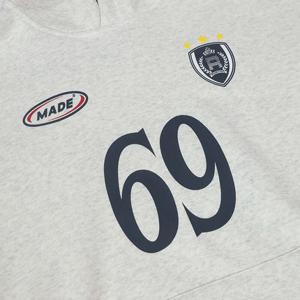 Close-up of an Oversized Hooded Sweatshirt – Loose Fit featuring number 69 and logo detail on a light gray fabric.