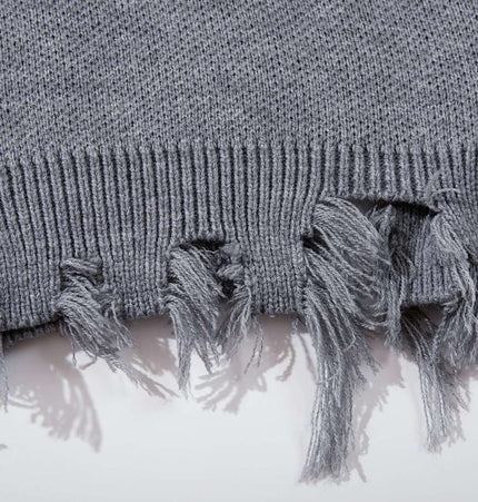 Close-up of the tassel detailing on the Tassel Distressed Knit Sweater – Loose Fit in grey.