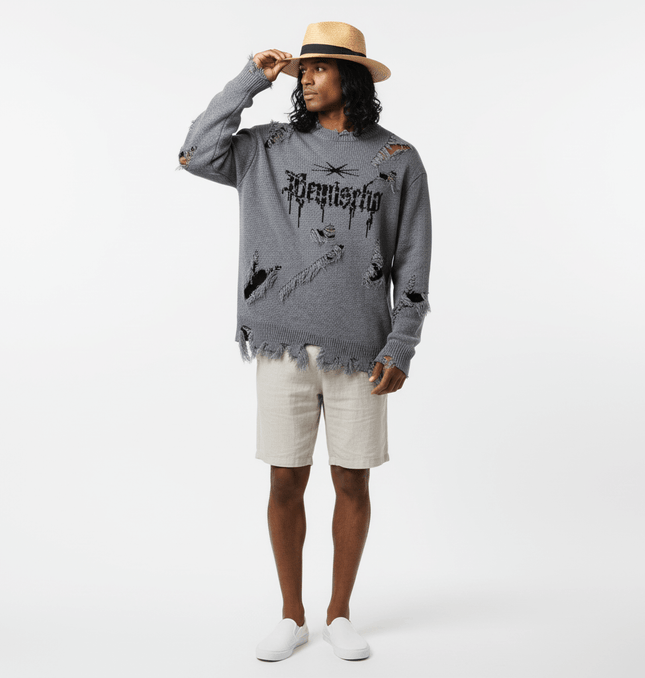 Tassel Distressed Knit Sweater – Loose Fit displayed on a model wearing shorts and a hat, showcasing a stylish urban look.