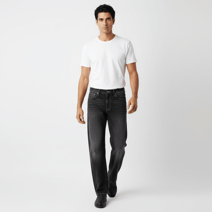 Man wearing Washed Straight Black Jeans – Loose Fit, paired with a white t-shirt, showcasing modern streetwear style.